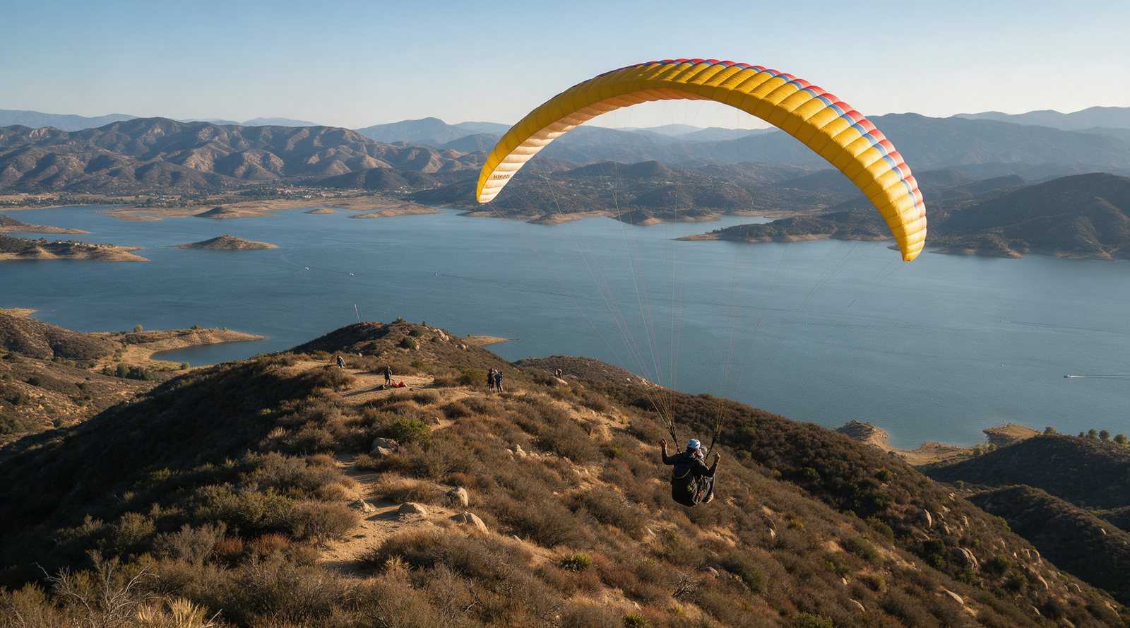 Paragliders thermaling above the ridge west of Lake Elsinore with the lake and valley below