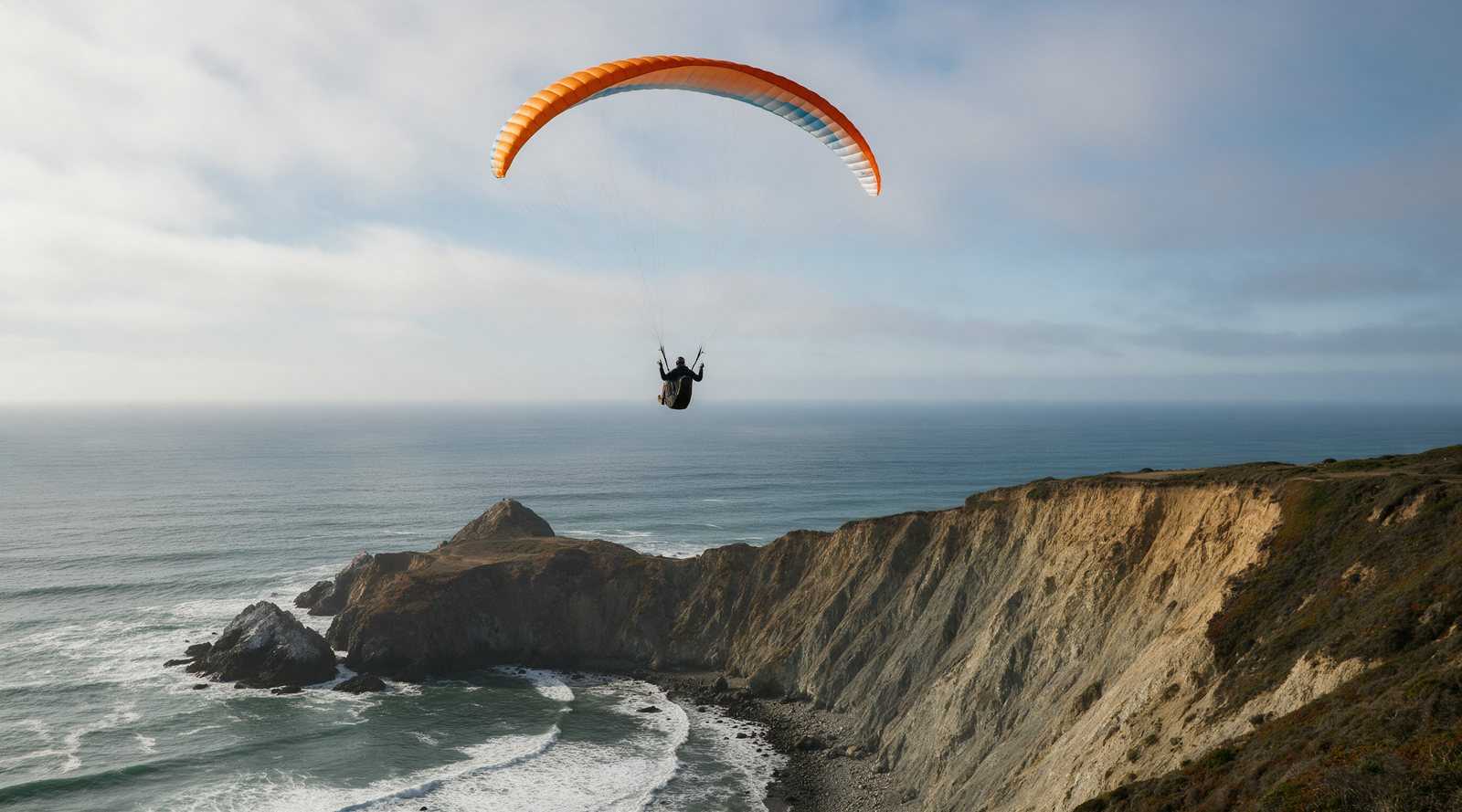 Paragliders soaring the coastal cliffs at Mussel Rock Park in Daly City, California
